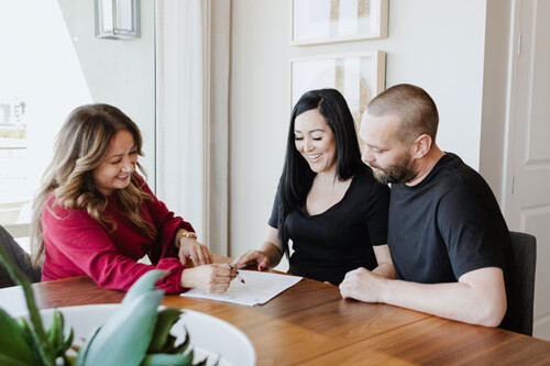 Realtor helping family sign papers for a new home