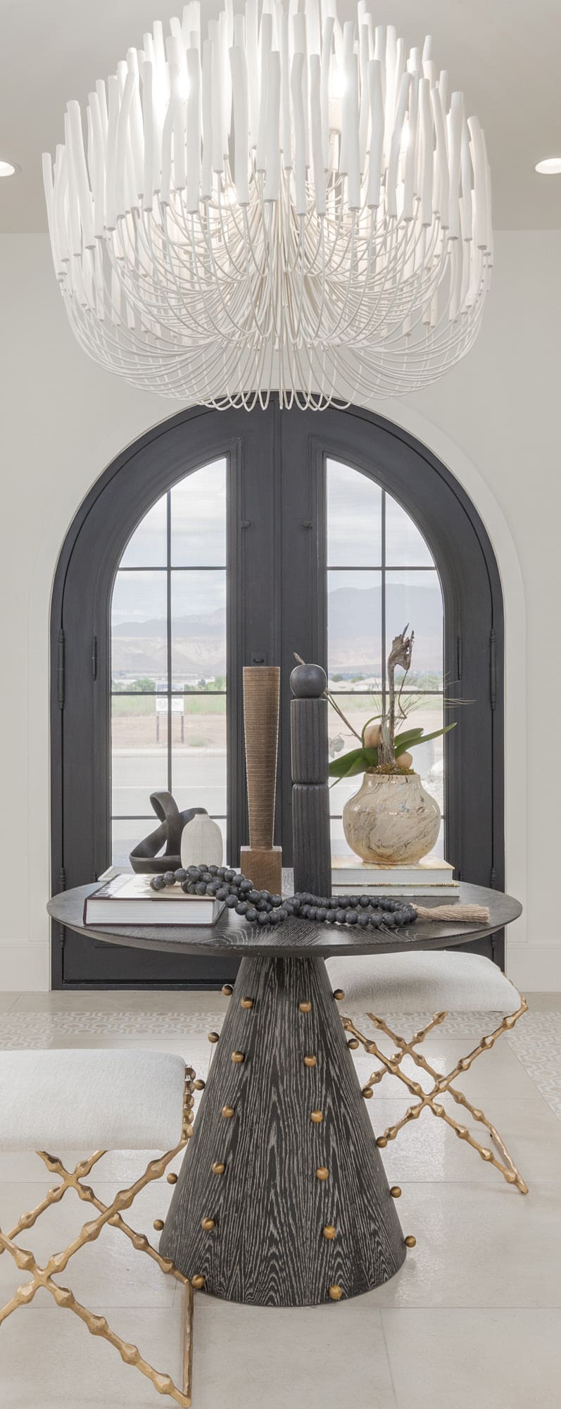 Professionally photographed home entry with arched doors and a statement chandelier